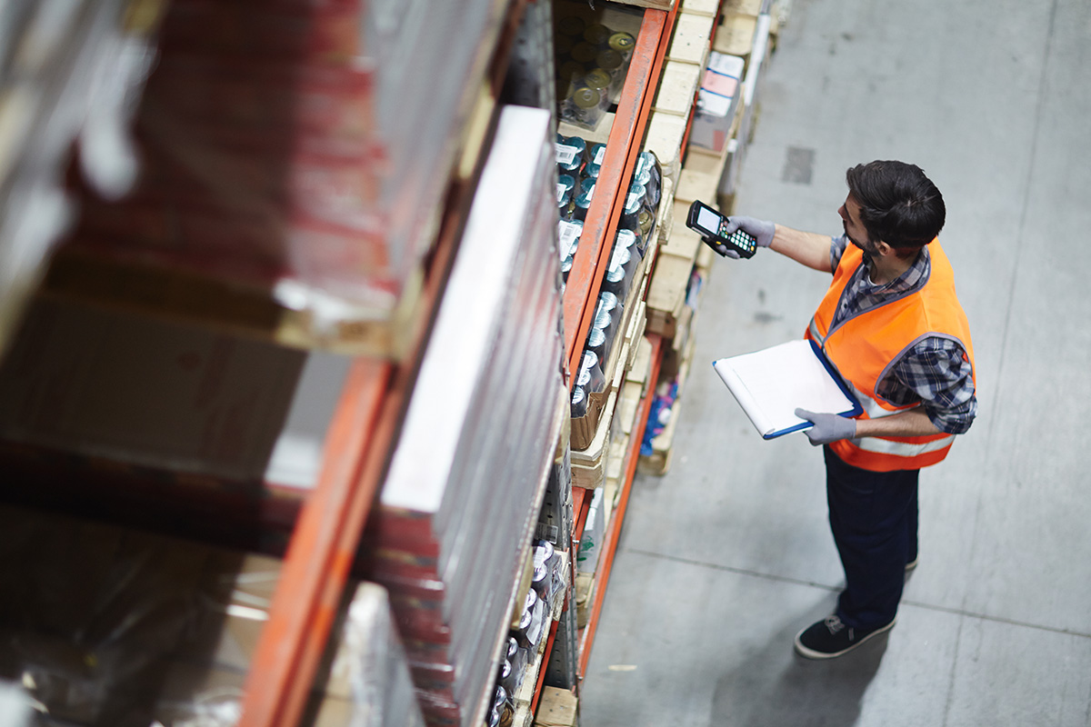 Warehouse worker scanning box with device